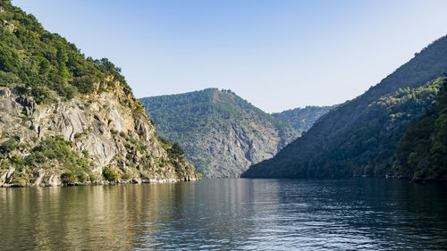 Scenic view of lake and mountains against clear sky