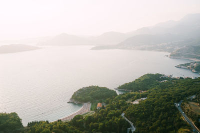 High angle view of sea and mountains against sky