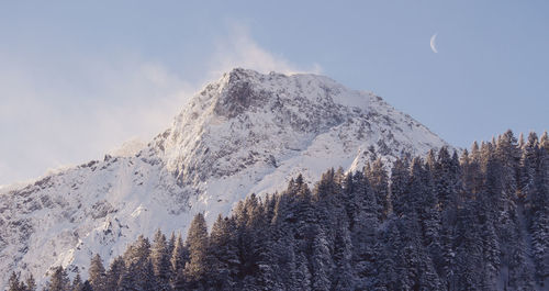 Low angle view of snow covered mountain against sky