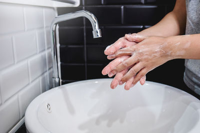 Midsection of woman in bathroom at home