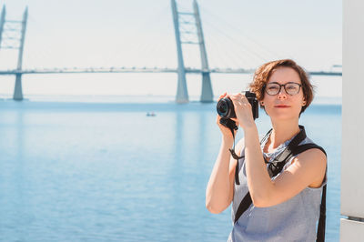 Portrait of woman standing against sea