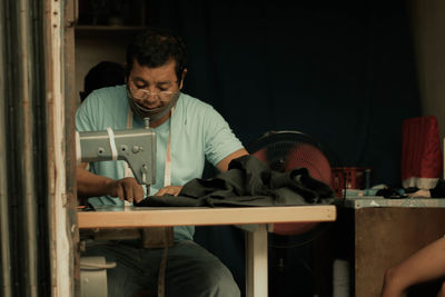 Man using mobile phone while sitting in kitchen