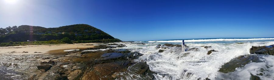 Panoramic view of beach against blue sky