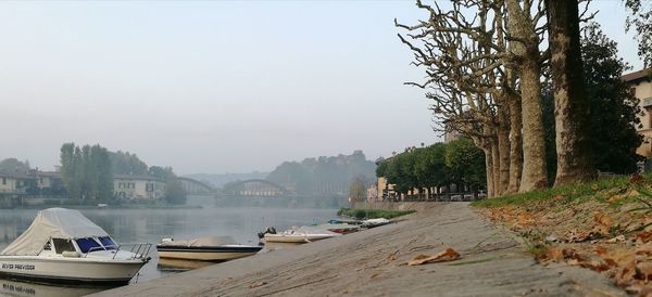 Boats moored in city against clear sky