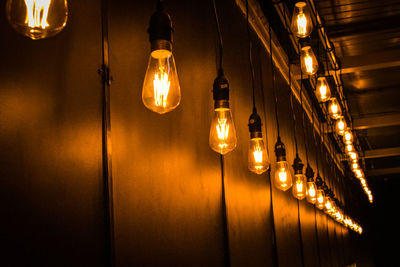 Illuminated light bulbs hanging from ceiling