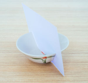 High angle view of paper stuck in bowl on table