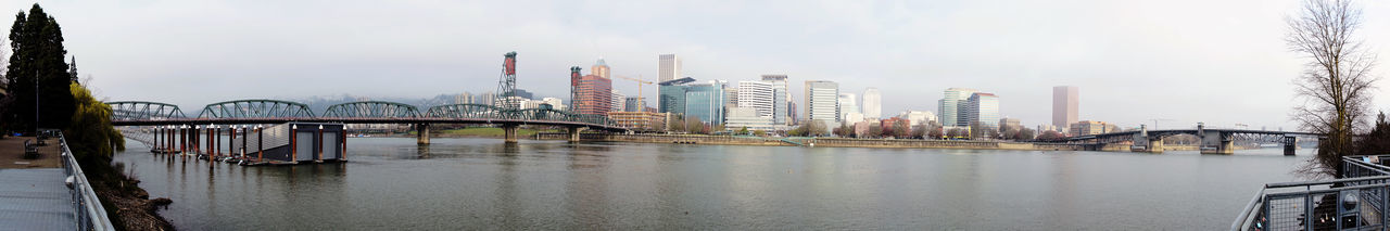 Bridge over river and buildings against sky