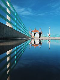 People on lake against sky