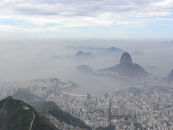 Aerial view of city by sea during foggy weather