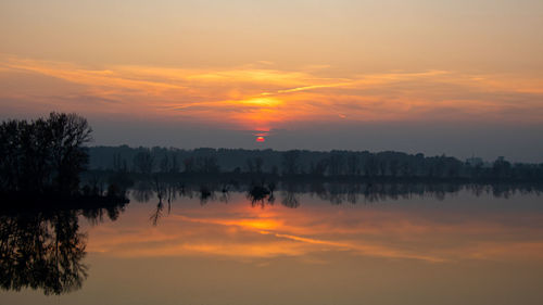 Scenic view of silhouette trees against romantic sky at sunset