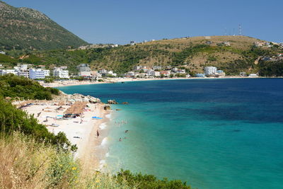 Scenic view of sea and mountains against clear blue sky