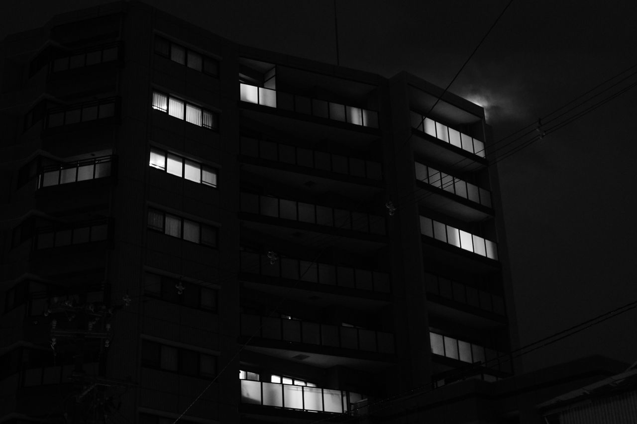 LOW ANGLE VIEW OF OFFICE BUILDING AT NIGHT