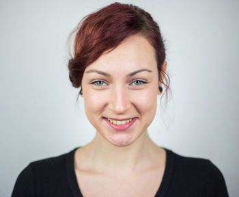 Portrait of a smiling young woman against white background