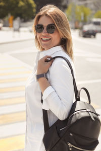 Portrait of smiling young woman wearing sunglasses