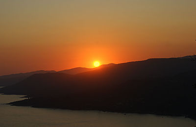 Scenic view of silhouette mountains against romantic sky at sunset