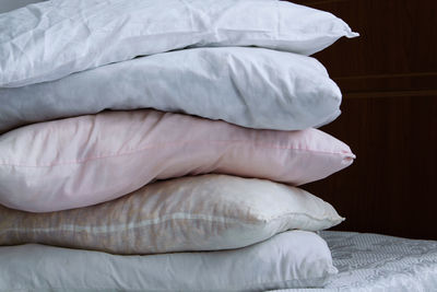 Close-up of stacked pillows on bed at home
