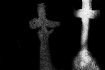 Close-up of cross against black background