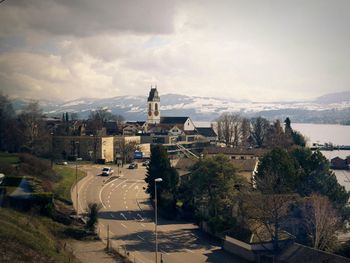 Buildings in town against cloudy sky