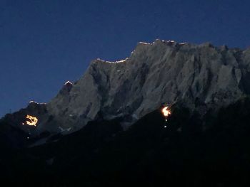 Low angle view of snowcapped mountains against sky at night