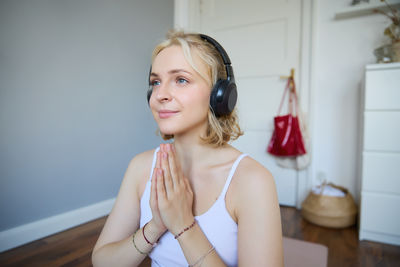 Portrait of young woman standing at home