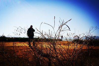 People standing on field at sunset