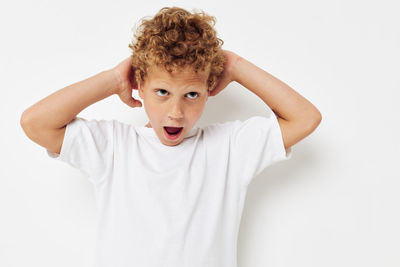 Boy gesturing against white background