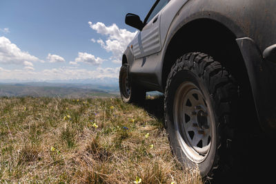 Suv wheel on the off-road adventure trail against the backdrop of mountains in the clouds