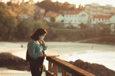 Woman standing on railing in city