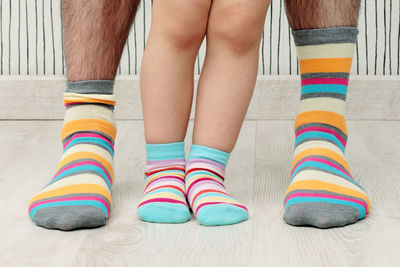 Low section of child standing on multi colored pencils