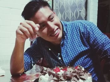 Portrait of smiling young man eating food