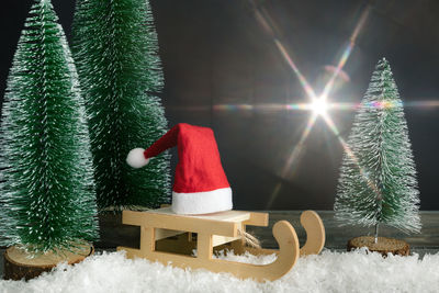 Close-up of christmas decorations on table against illuminated light