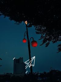 Low angle view of illuminated street light against blue sky