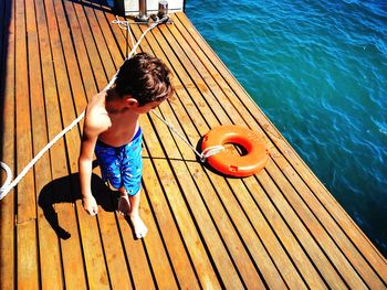 High angle view of boy on pier over sea