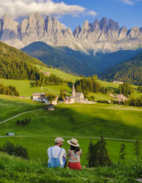 Rear view of woman walking on field against mountains