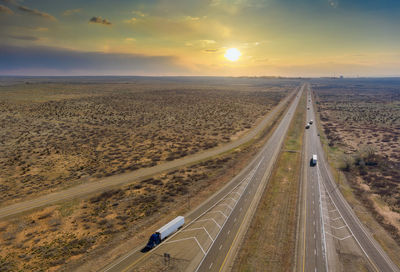 High angle view of road amidst land against sky during sunset