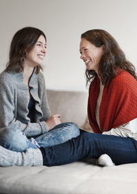 Mother and teenage daughter on sofa