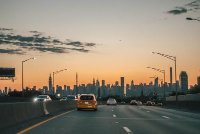 Traffic on road at sunset