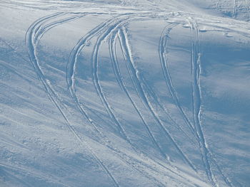 High angle view of tire tracks on snow covered mountain