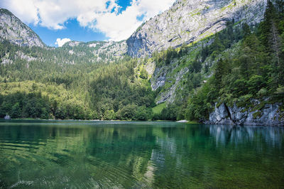 Scenic view of lake by mountain against sky