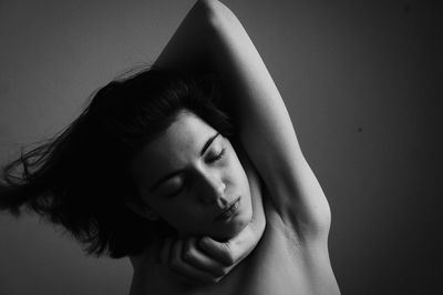 Close-up of young woman against gray background