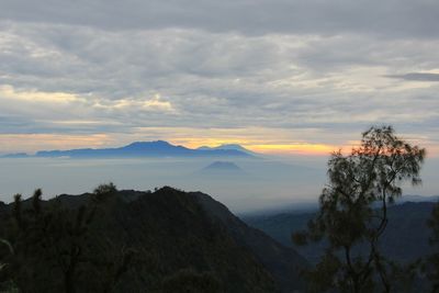 Scenic view of mountains against cloudy sky