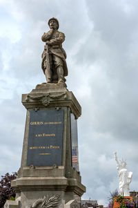 Low angle view of monument against cloudy sky