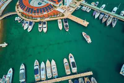 Aerial view of modern yachts and boats docking in marina on sunny summer day