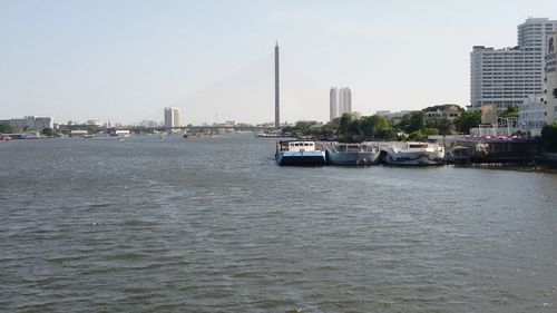 Boats in river with city in background