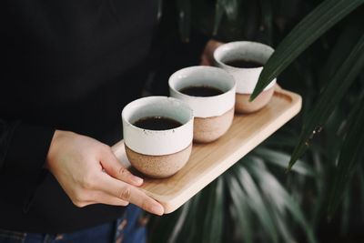 Cropped image of hand holding coffee cup