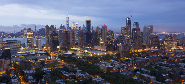 Illuminated buildings in city against sky