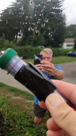 Midsection of couple holding hands on field