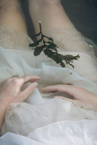 Midsection of woman with twig in lake