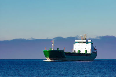 Ship sailing in sea against blue sky