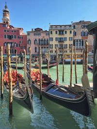 Gondolas moored on river against residential buildings